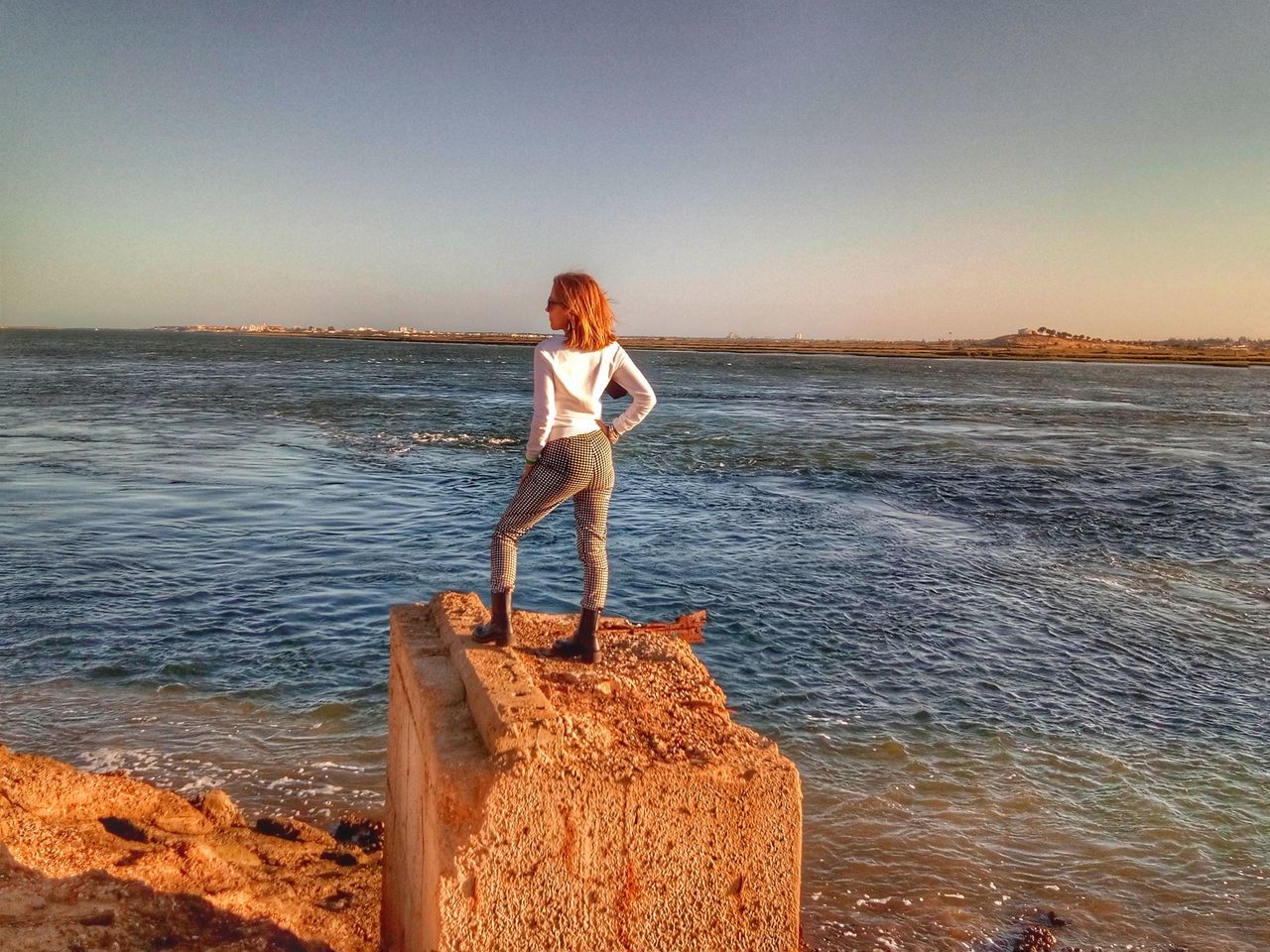 FULL LENGTH OF MAN STANDING ON ROCK AT BEACH AGAINST SKY