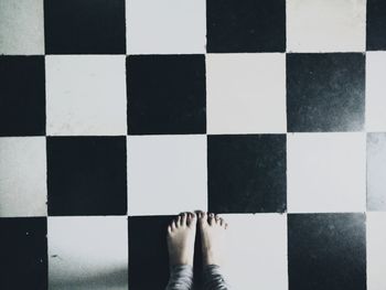 Low section of woman standing on tiled floor