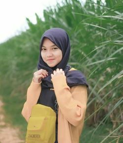 Portrait of beautiful woman standing on field