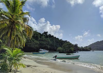 Boat moored on beach against sky