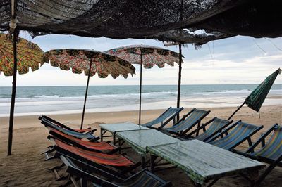 Lounge chairs and beach umbrellas with tables on beach