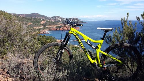 Bicycle by sea against sky