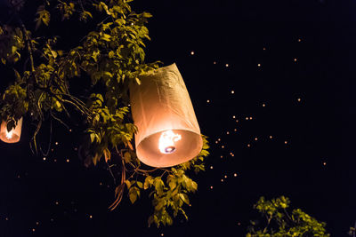 Low angle view of illuminated lantern against sky at night