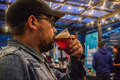 Close-up of man drinking drink indoors