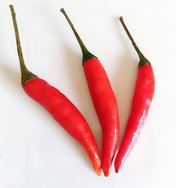 Close-up of red chili peppers on white background