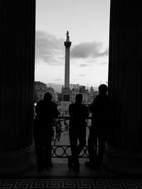 Silhouette people looking at monument in city