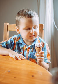 Portrait of boy eating food at home