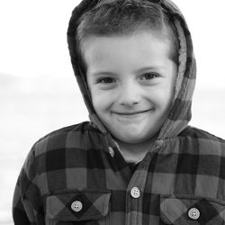 Black and white sweet little boy in hooded jacket 