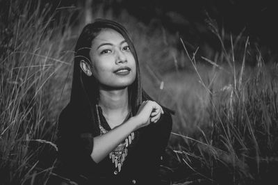 Beautiful young woman standing in grass at night