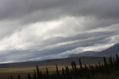 Scenic view of land and mountains against sky