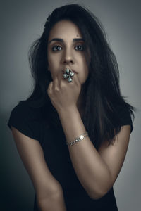 Portrait of young woman against gray background