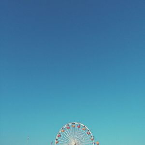 Ferris wheel at santa monica against clear blue sky on sunny day