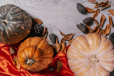 Autumnal background with harvest fall vegetables and autumnal leaves on wooden background