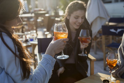 Young women sitting in bar drinking aperitif