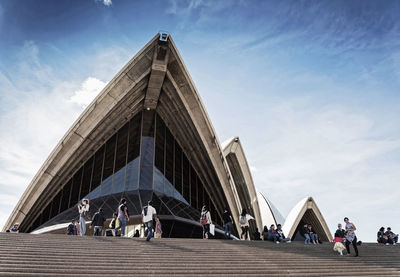 Low angle view of people walking on modern building