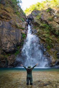 Rear view of man standing on rock