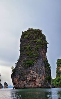 Rock formations by sea against sky