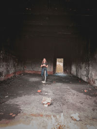 Full length of woman standing in abandoned building