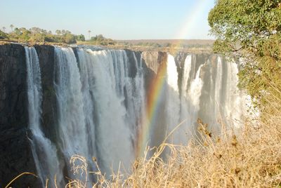 Scenic view of waterfall against sky