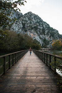 Rear view of woman walking on footbridge