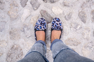 Low section of woman standing on footpath