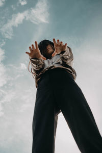 Low angle view of woman standing against sky