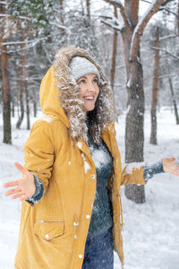 Portrait of a smiling woman standing in snow