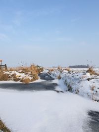 Scenic view of snow covered land against sky