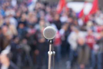 Close-up of microphone against crowd