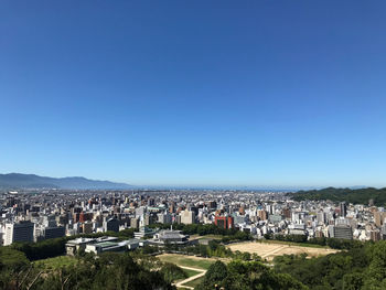 High angle view of townscape against clear blue sky