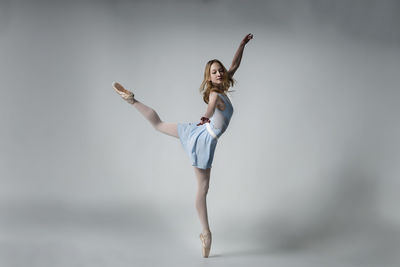 Ballet dancing against gray background