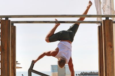 Rear view of man photographing against clear sky