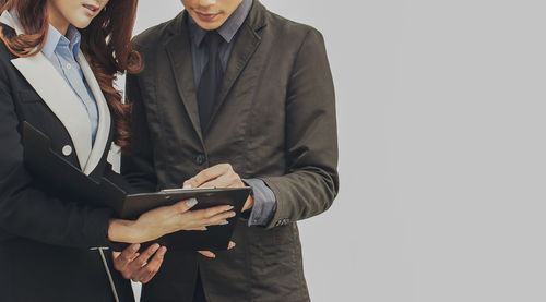 Midsection of a man holding smart phone
