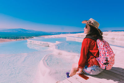 Woman sitting on snowy looking at view