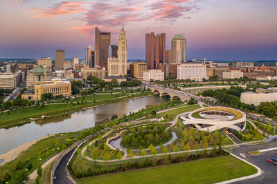 Aerial view of city buildings against cloudy sky