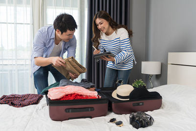 Portrait of smiling family sitting on bed at home