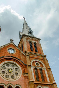 Low angle view of clock tower against cloudy sky