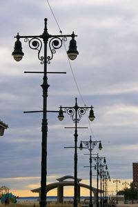 Low angle view of street light against cloudy sky