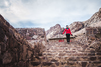 Full length of woman standing on staircase against sky