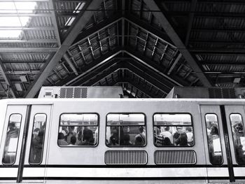 Low angle view of people traveling in train at station
