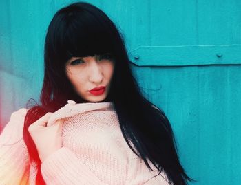 Portrait of beautiful woman against wall