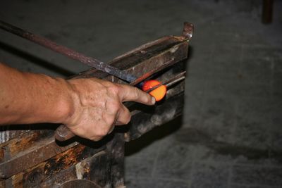 Cropped hand holding work tools in workshop