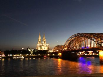 Illuminated bridge over river at night