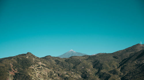 Scenic view of mountains against clear blue sky