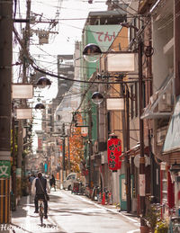 People walking on road amidst buildings in city