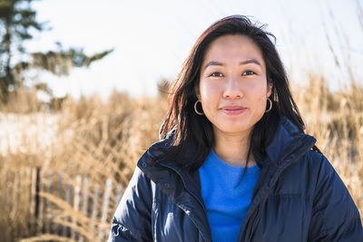 Closeup portrait of asian woman outdoors smiling at the beach