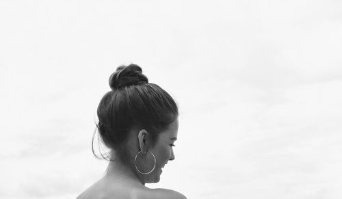 Rear view of woman looking at camera against sky