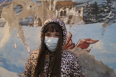 Portrait of girl standing against wall