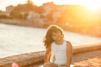 Smiling young woman at beach during sunset