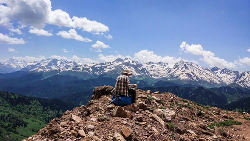 Man standing on snowcapped mountain against sky